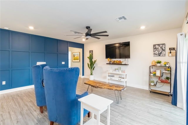 living area featuring ceiling fan and light hardwood / wood-style flooring