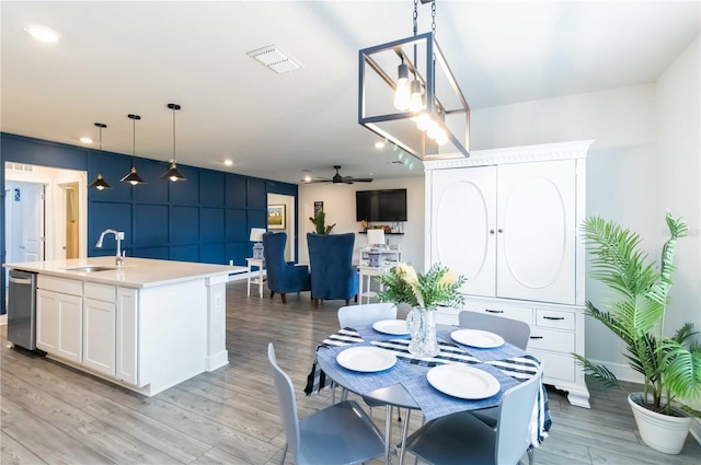 dining room featuring light hardwood / wood-style flooring, sink, and ceiling fan