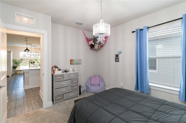 bedroom with dark wood-type flooring, a notable chandelier, and sink