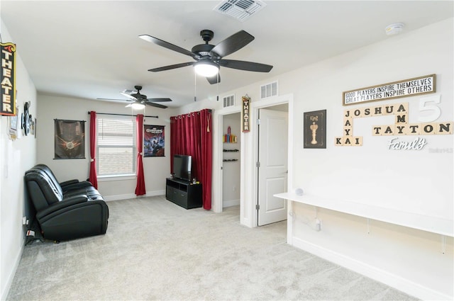 living area with light carpet and ceiling fan