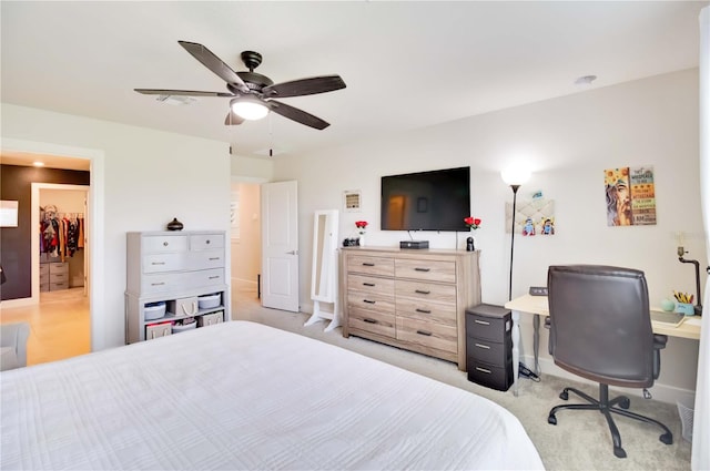 carpeted bedroom featuring a closet, ceiling fan, and a walk in closet