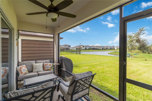 sunroom / solarium featuring a water view and ceiling fan