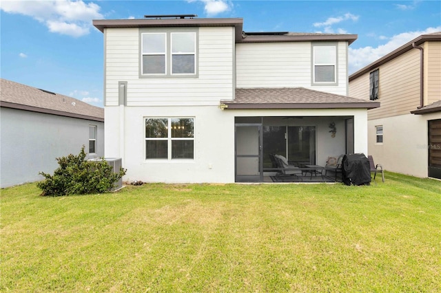 back of property with central air condition unit and a lawn