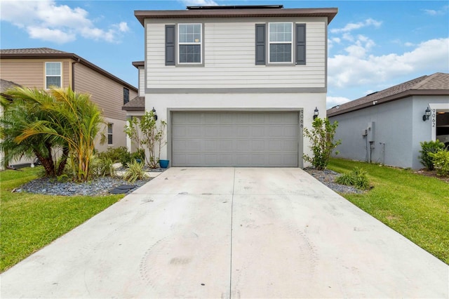 view of property featuring a front lawn and a garage