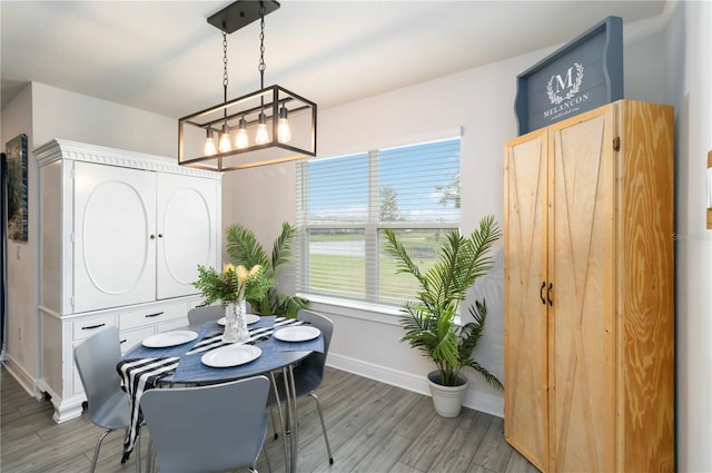 dining space with hardwood / wood-style floors and a chandelier