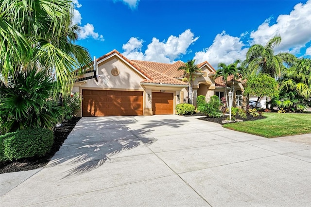 mediterranean / spanish home featuring a front lawn and a garage