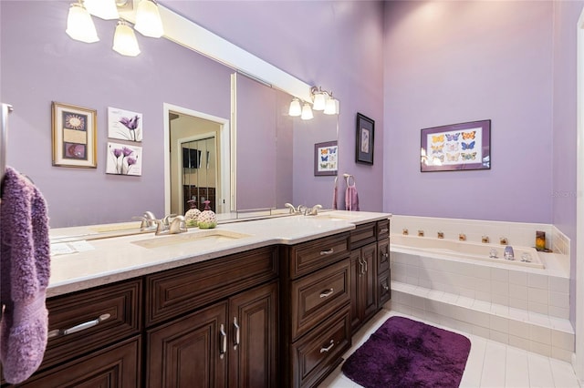 bathroom with vanity, a relaxing tiled tub, and tile patterned flooring