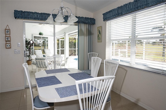 tiled dining space featuring a notable chandelier and a healthy amount of sunlight