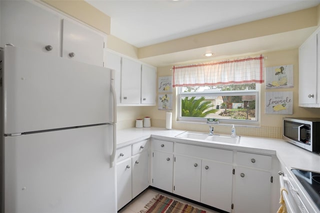 kitchen with white fridge, range, sink, and white cabinets