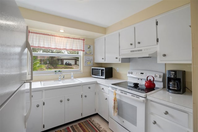 kitchen featuring sink, white cabinets, white appliances, and light tile patterned floors