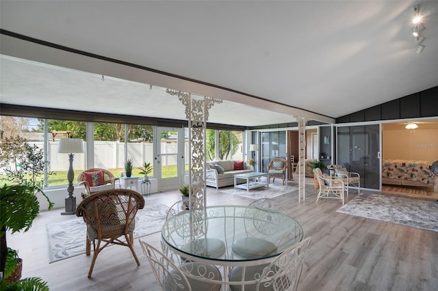 sunroom / solarium with decorative columns and vaulted ceiling