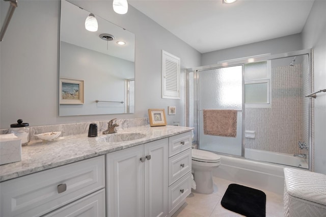 full bathroom featuring vanity, toilet, shower / bath combination with glass door, and tile patterned flooring