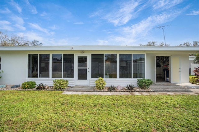 back of house featuring a yard and a sunroom