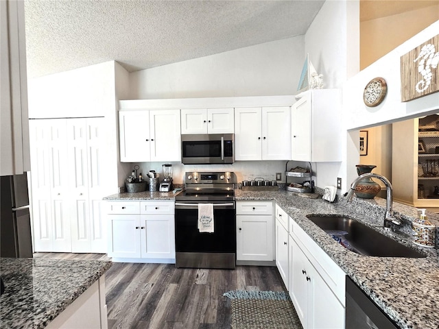 kitchen with sink, appliances with stainless steel finishes, dark wood-type flooring, and white cabinetry