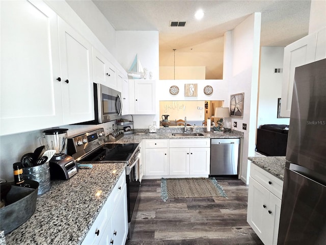 kitchen featuring stainless steel appliances, a textured ceiling, dark hardwood / wood-style flooring, and white cabinets