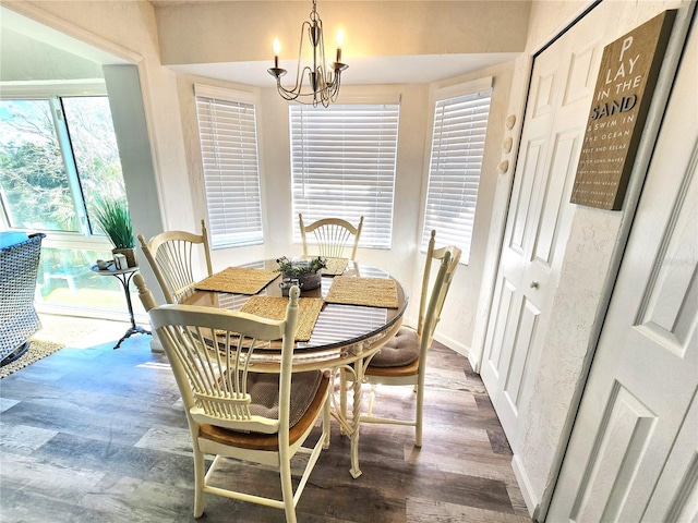 dining space with wood-type flooring and an inviting chandelier