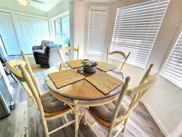 dining room with ceiling fan, hardwood / wood-style flooring, and lofted ceiling