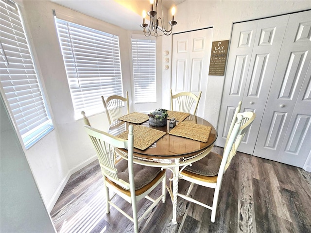 dining area with an inviting chandelier and dark hardwood / wood-style flooring