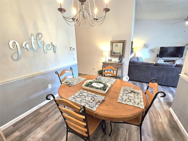 dining space featuring wood-type flooring, lofted ceiling, and ceiling fan with notable chandelier