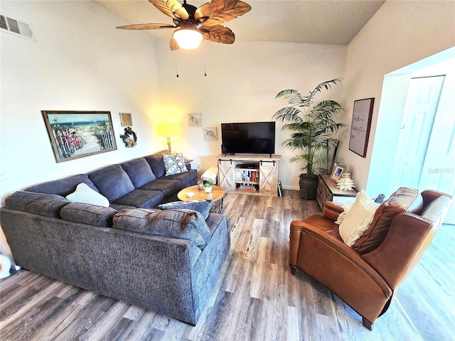 living room featuring ceiling fan, hardwood / wood-style flooring, and lofted ceiling