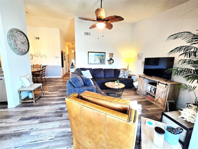 living room with a textured ceiling, hardwood / wood-style flooring, and ceiling fan