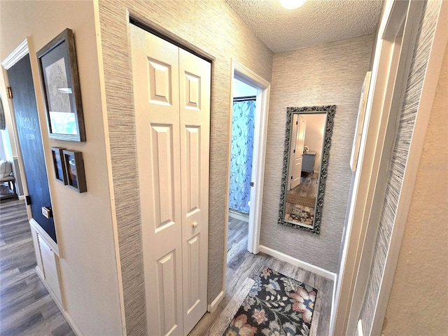 hallway featuring hardwood / wood-style flooring and a textured ceiling