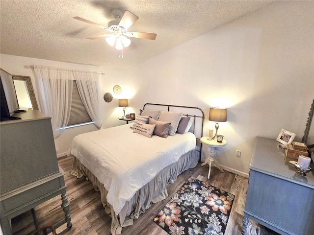 bedroom with ceiling fan, a textured ceiling, and dark hardwood / wood-style flooring