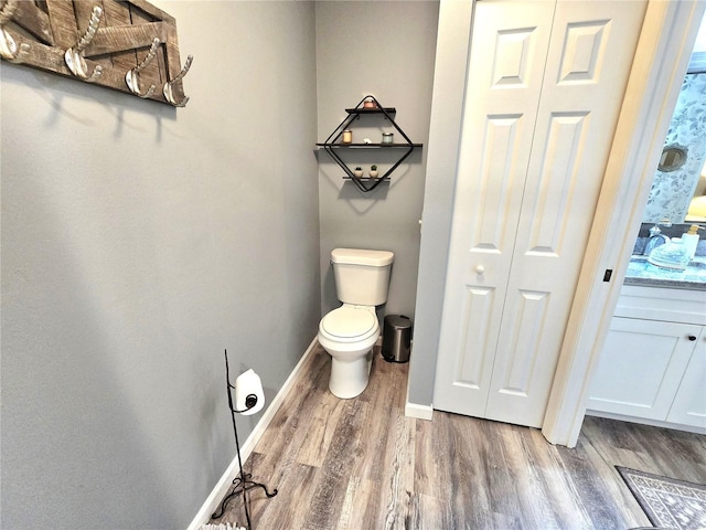 bathroom with hardwood / wood-style flooring and toilet