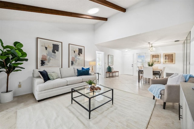 living room featuring vaulted ceiling with beams, a notable chandelier, a textured ceiling, and light tile patterned floors