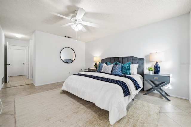 bedroom featuring a textured ceiling, light tile patterned flooring, and ceiling fan