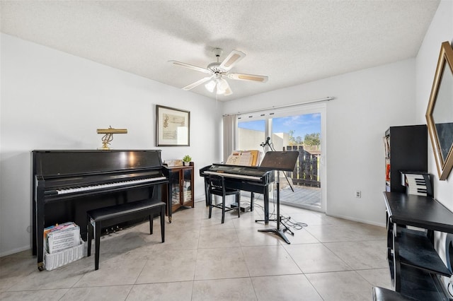 misc room with a textured ceiling, light tile patterned flooring, and ceiling fan