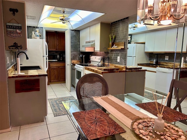 kitchen with sink, decorative backsplash, white appliances, and light tile patterned floors