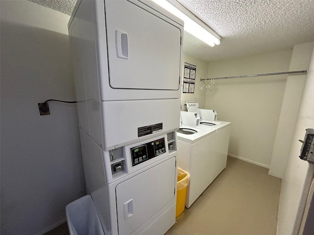 laundry area with stacked washer and clothes dryer and a textured ceiling