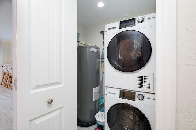 washroom with stacked washer / dryer and electric water heater