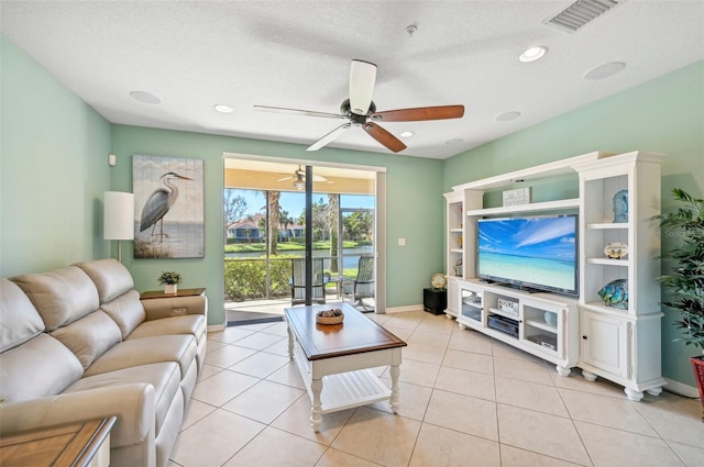 tiled living room with a textured ceiling and ceiling fan