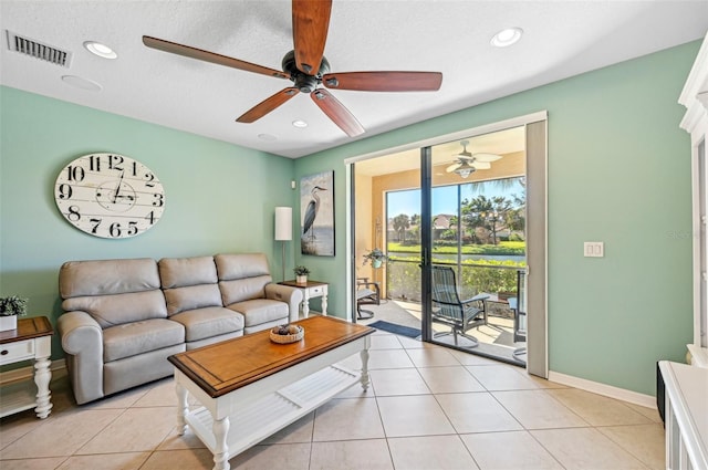 living room with a textured ceiling and light tile patterned flooring