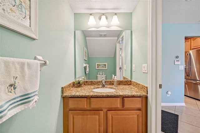 bathroom with a textured ceiling, vanity, and tile patterned flooring