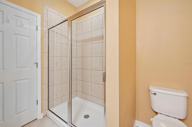 bathroom featuring toilet, an enclosed shower, and tile patterned floors