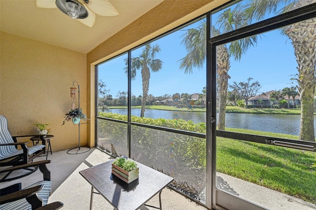 unfurnished sunroom with ceiling fan and a water view