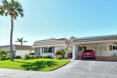 single story home featuring a front yard and a carport