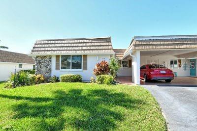 ranch-style home with a carport and a front yard