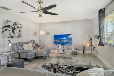 living room with hardwood / wood-style floors and ceiling fan