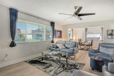 living room with hardwood / wood-style floors, ceiling fan, and a wealth of natural light