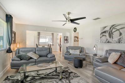 living room featuring light hardwood / wood-style floors and ceiling fan