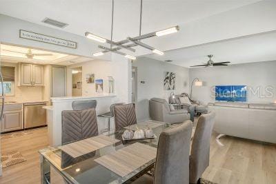 dining area featuring ceiling fan with notable chandelier and light hardwood / wood-style floors