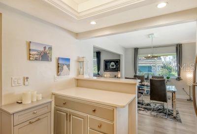 kitchen with light hardwood / wood-style floors, crown molding, kitchen peninsula, and hanging light fixtures