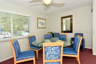 carpeted dining space with ceiling fan