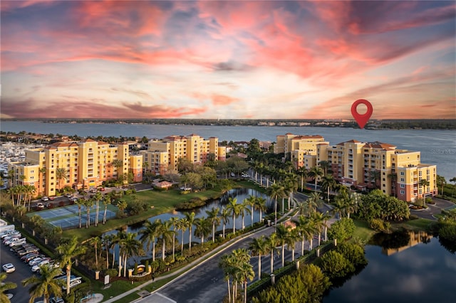 aerial view at dusk featuring a water view