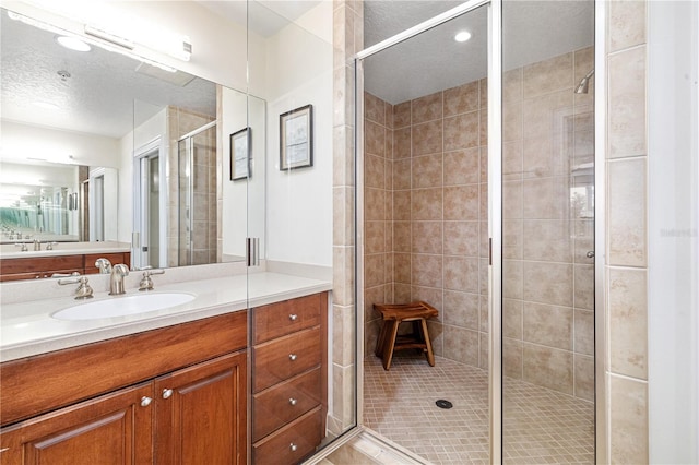 bathroom with vanity, tile patterned floors, walk in shower, and a textured ceiling