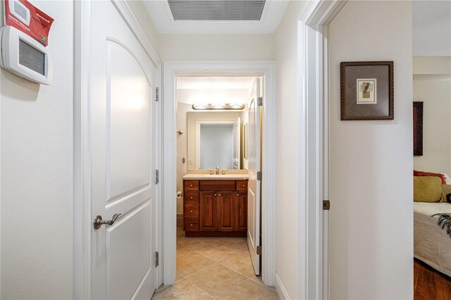 corridor with light tile patterned floors and sink